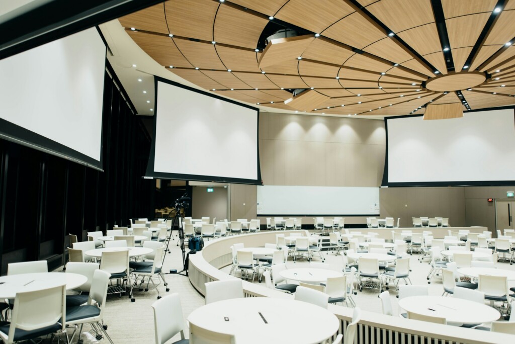 Salle de conférence avec tables rondes préparée pour un événement d'affaires